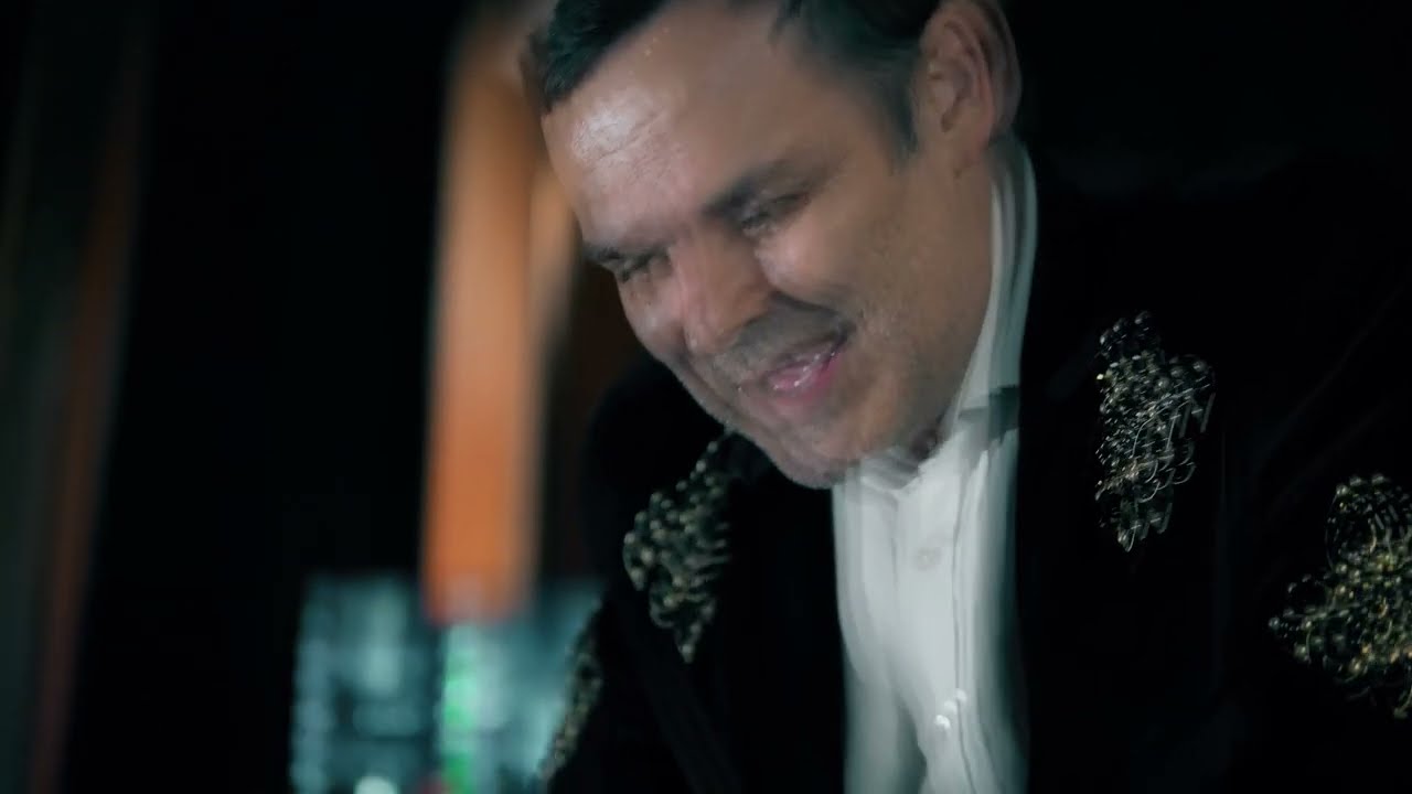 Le collectionneur éclate de rire dans la pénombre