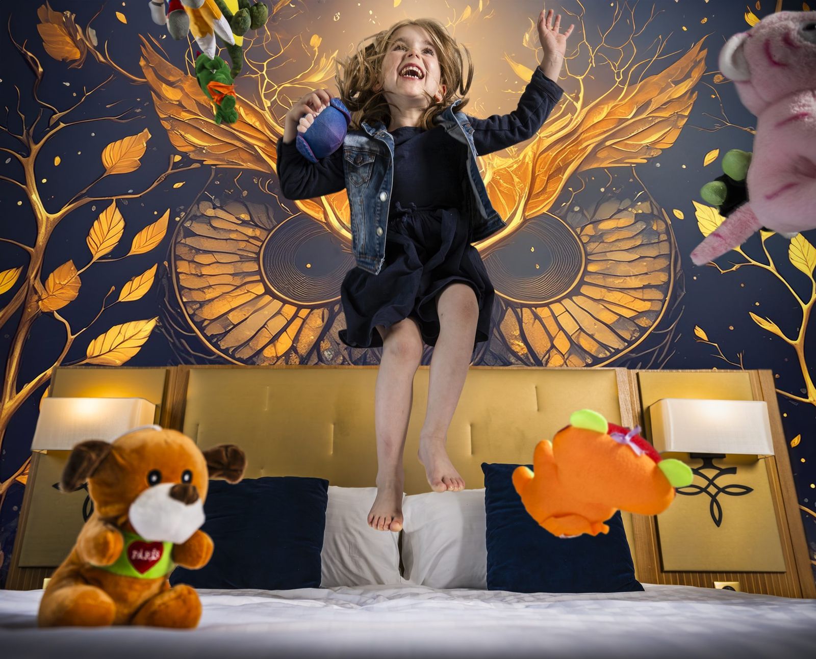Image de campagne pour un hôtel familial : une enfant saute sur un lit devant une fresque murale dorée